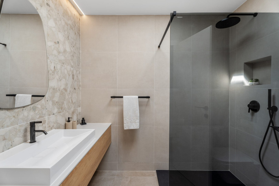 An en-suite bathroom with a shower, a sink, and a toilet