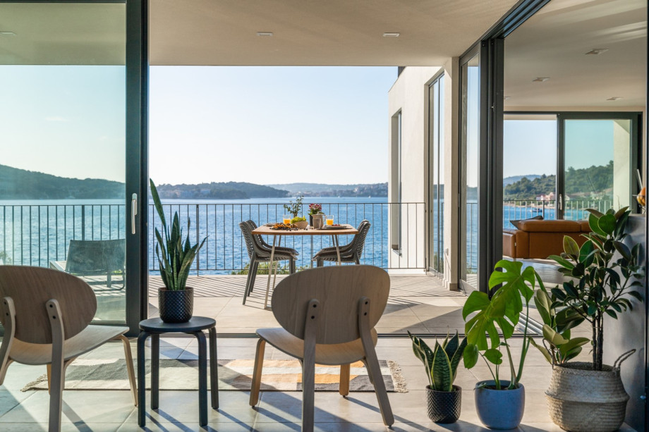 eine überdachte Terrasse mit Esstisch auf der Westseite