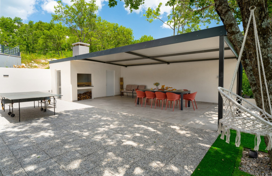 Closed summer kitchen that consists of a fridge, dishwasher, hob, and a separate toilet