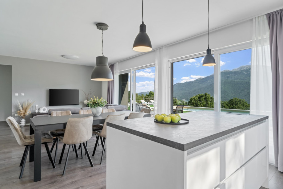 There is a kitchen island and stools, all high-quality furnished with slide doors toward the pool area overviewing the valley and Biokovo mountain