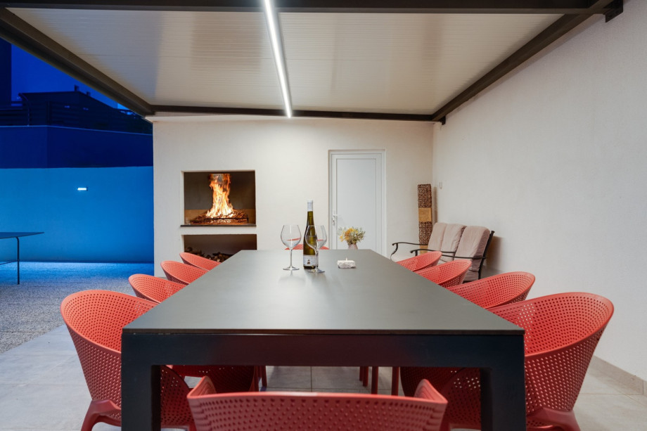 A covered outdoor dining area with the traditional barbecue