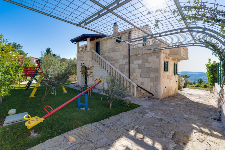 Playground with swing and slide next to barbecue