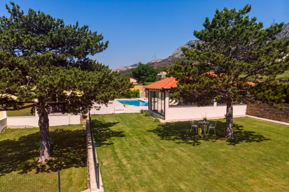 Grass plot with playground for kids just next to summer kitchen