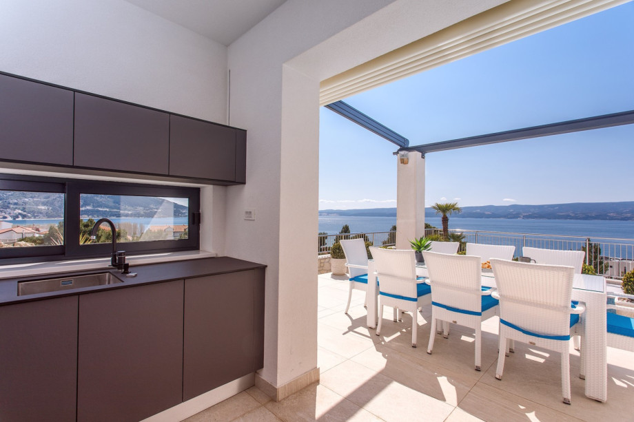 An outdoor dining area for 8, and a traditional barbecue next to it