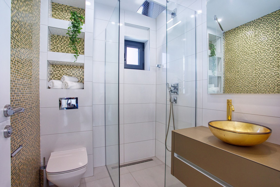 An en-suite bathroom with a shower, a sink, and a toilet