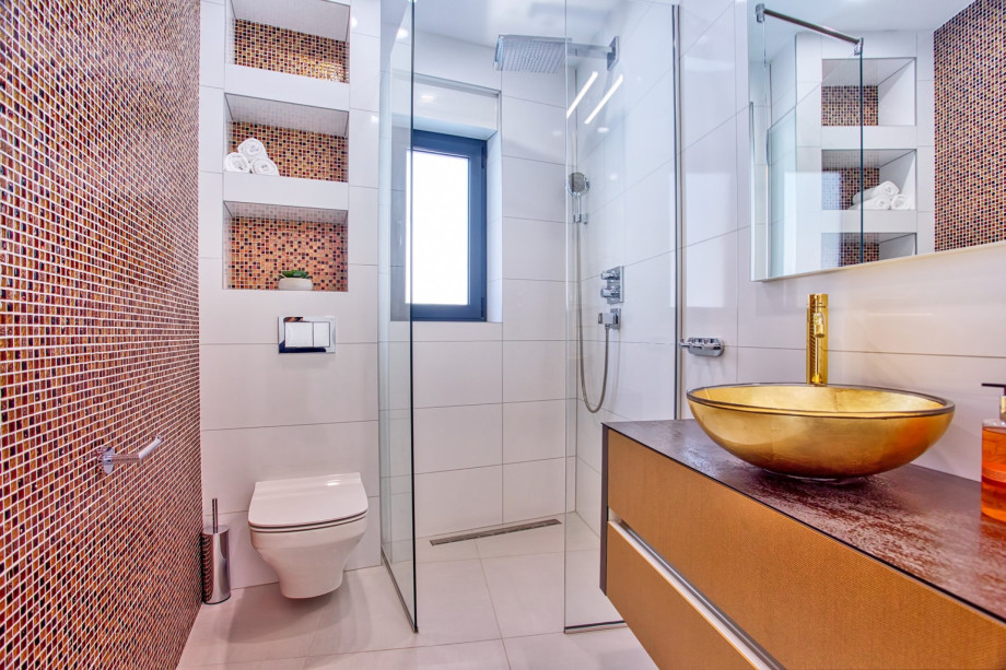 An en-suite bathroom with a shower, a sink, and a toilet