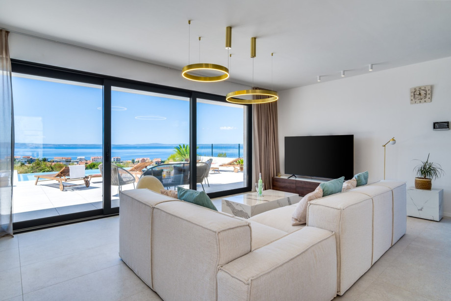 Large glass walls connect the villa's interior with the exterior, boasting a modern swimming pool area, bringing so much welcomed natural sunlight inside