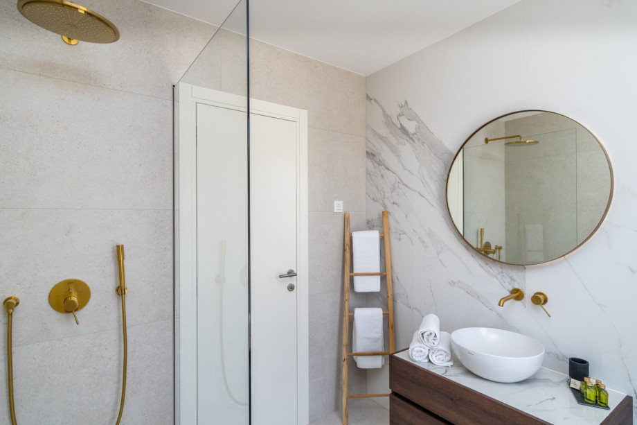 An en-suite bathroom with a shower, a sink, and a toilet