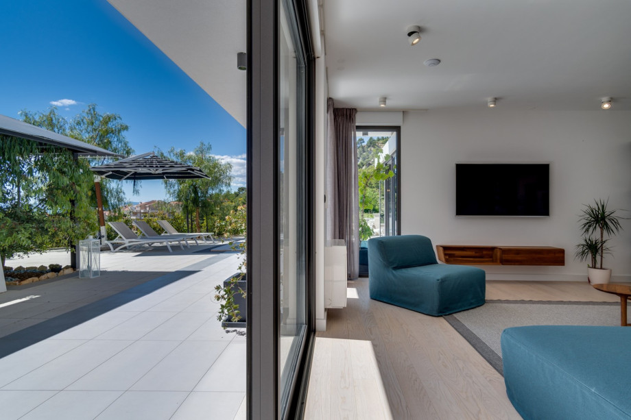 The ground floor offers a fully air-conditioned, open-plan living and dining area with floor-to-ceiling glass doors