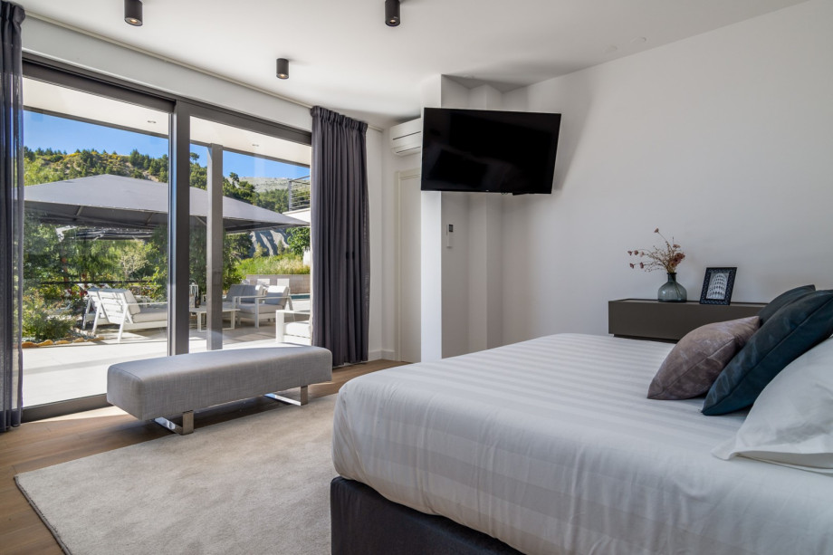 Bedroom No1 also offers a glass door with pool views, A/C, and a TV.