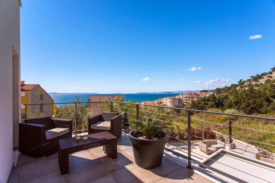 Bedroom No4 offers a terrace with a lounge corner and views of the pool and the sea.