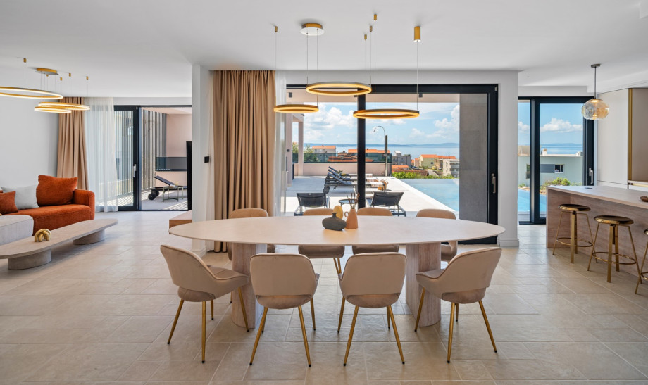 Large glass walls connect the villa's interior with the exterior, boasting a modern swimming pool area