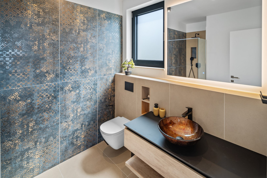 An en-suite bathroom with a shower, a sink, and a toilet