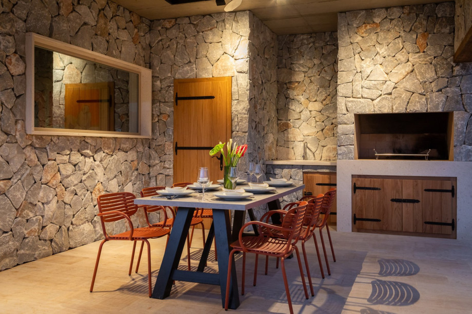 There is a covered outdoor dining area with a barbecue