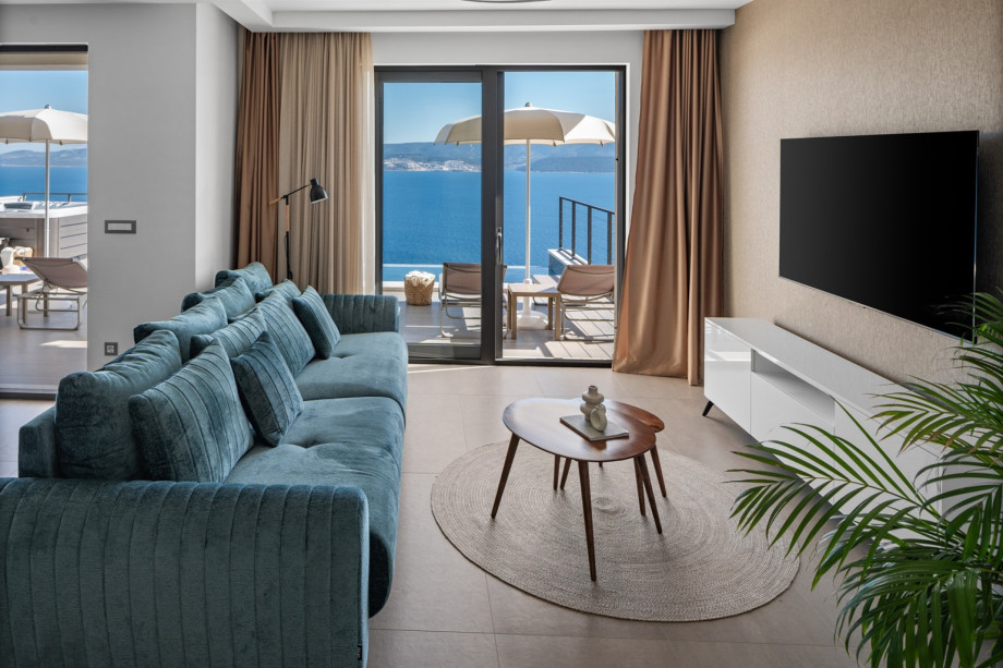 The living space is designed with large glass doors that flood the space with natural light and connect you to the pool and sea views