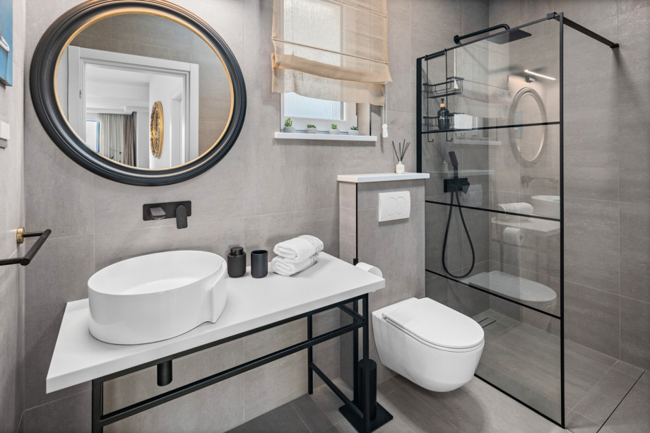 A family bathroom with a shower and a laundry room with ironing amenities, a washing machine, and a dryer.