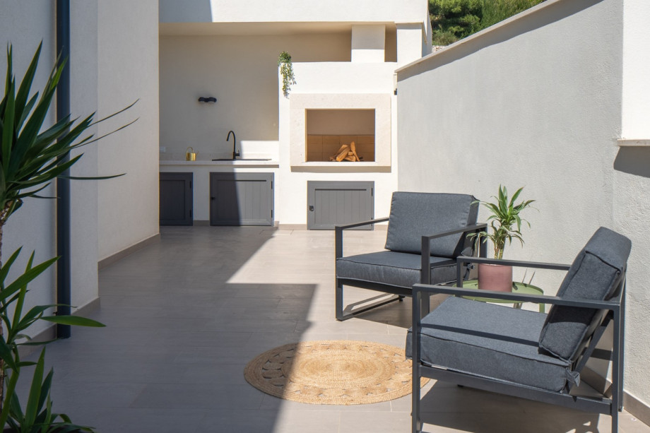 A barbecue area with a kitchen top and sink