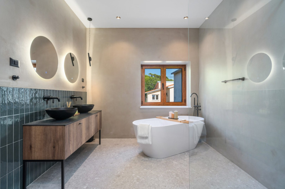 En-suite bathroom with a self-standing bathtub and a shower, a double sink, a toilet