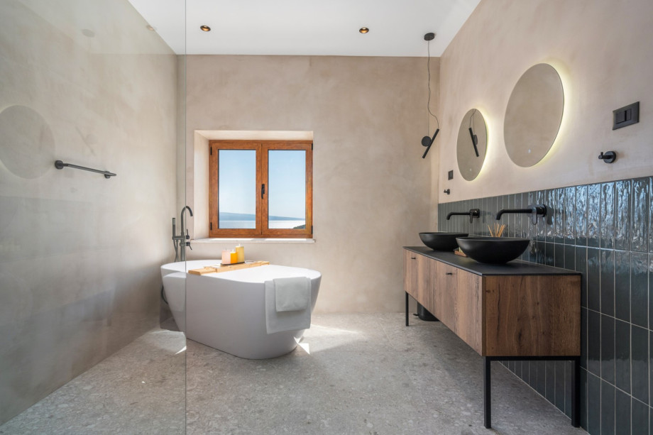 En-suite bathroom with a self-standing bathtub and a shower, a double sink, a toilet