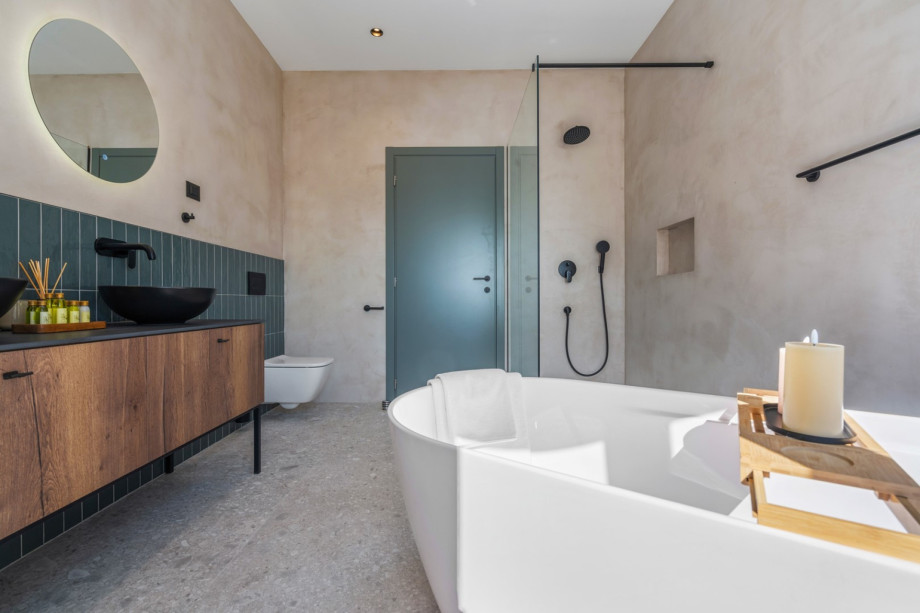En-suite bathroom with a self-standing bathtub and a shower, a double sink, a toilet
