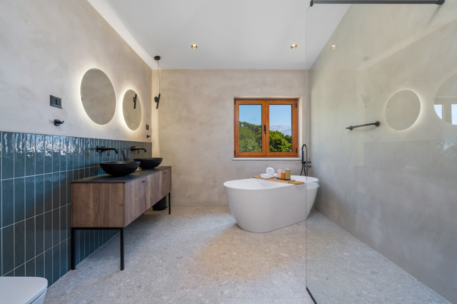 En-suite bathroom with a self-standing bathtub and a shower, a double sink, a toilet.