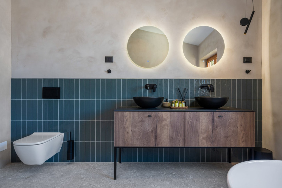 En-suite bathroom with a self-standing bathtub and a shower, a double sink, a toilet.