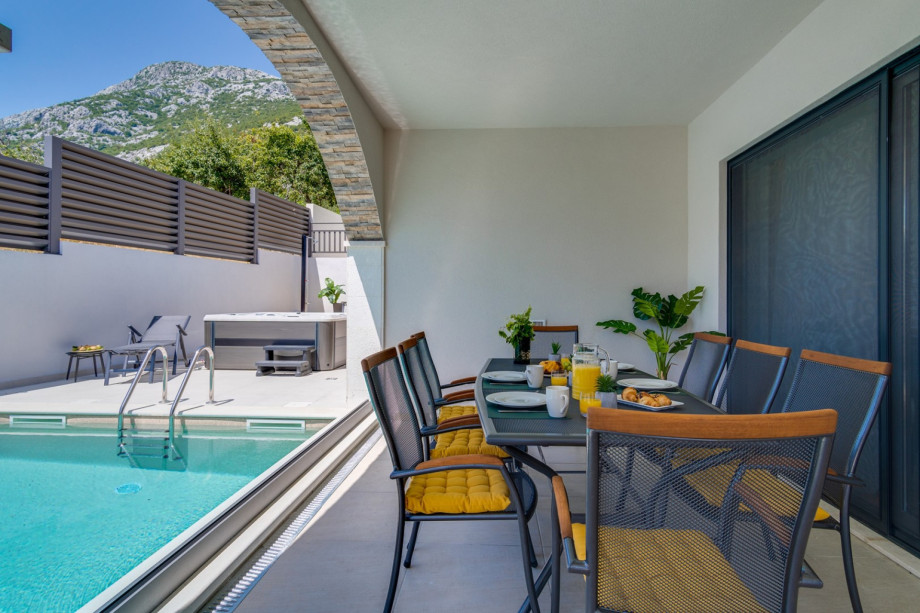 A covered outdoor dining area for 8 people (with a direct approach to the indoor kitchen) with a gas grill