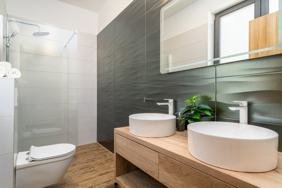 An en-suite bathroom with a shower, a double sink, and a toilet