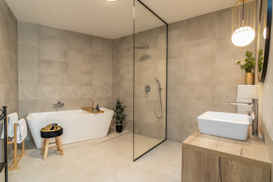 An en-suite bathroom with a bathtub, a shower, a sink, and a toilet