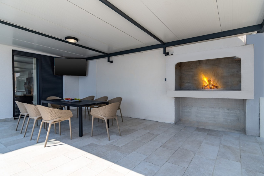 An outdoor dining area for 8, and a traditional barbecue next to it