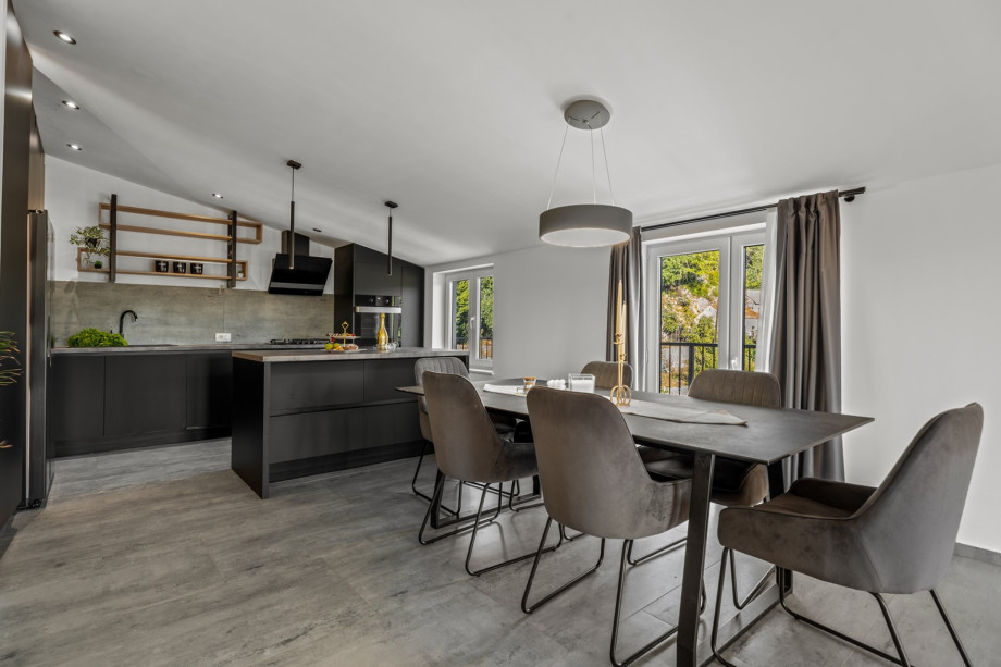 Wohnbereich mit Balkon mit Blick auf den Pool und das Tal