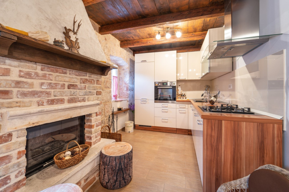Cozy kitchen area combining modern appliances and traditional stone details.