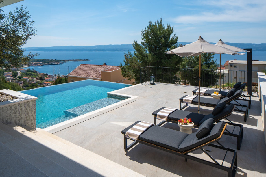 Private heated swimming pool, which measures 9.5m x 4.5m and includes a sitting bench and hydromassage feature