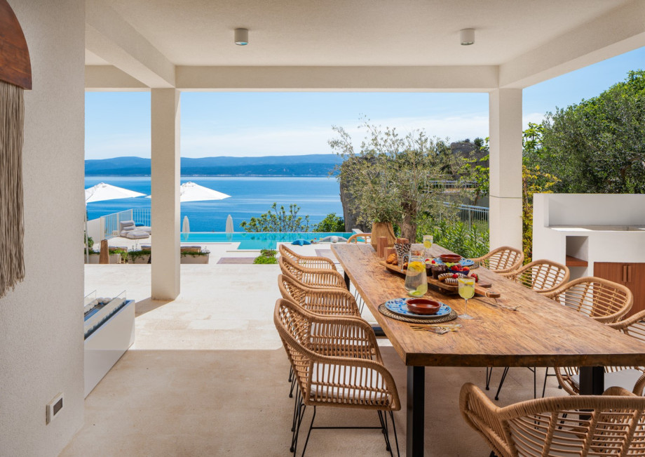 The covered outdoor area is a true oasis, complete with a private terrace and pool overlooking the azure sea