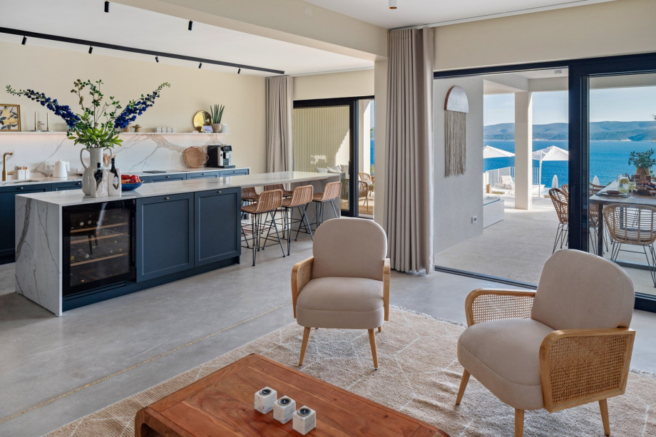 A fully equipped kitchen with a spacious kitchen island with stools, a Delonghi coffee maker, a microwave oven, and everything you need to cook