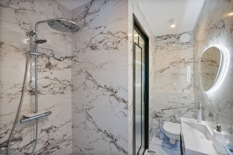 An en-suite bathroom with a shower, a sink, and a toilet