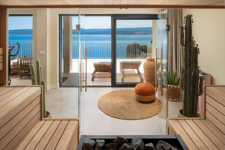 The glass doors also lead to a terrace that has an outdoor shower, two deck chairs, and a lounge area