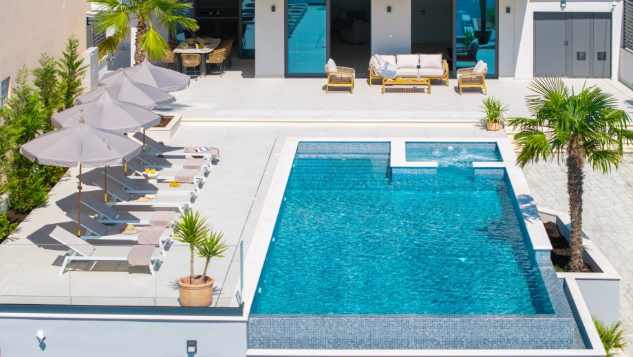 Expansive sun deck with 8 comfortable deck chairs, outdoor shower, and vibrant parasols for those sunny days