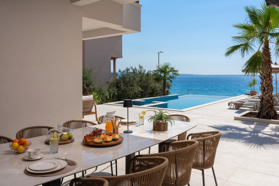 A fully equipped summer kitchen complete with a kitchen island and a covered dining area