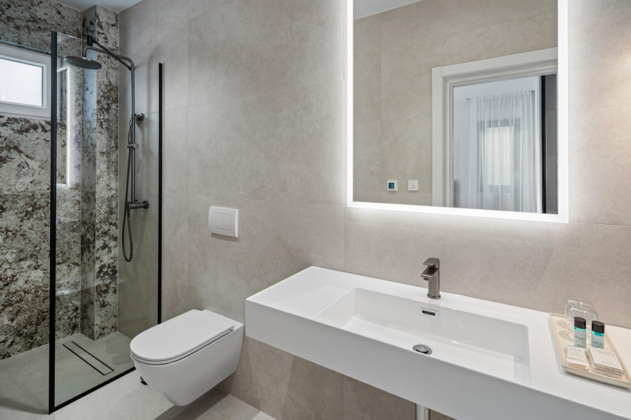 En-suite bathroom with shower, balcony, and sea views