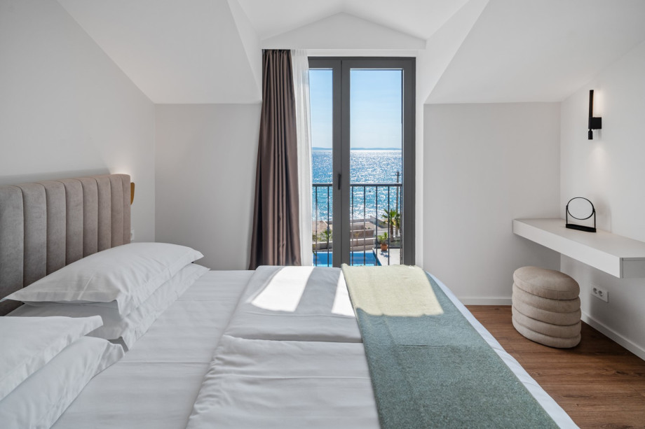 The bedroom opens to a private balcony that offers breathtaking views of the sea – the perfect setting for relaxing moments.