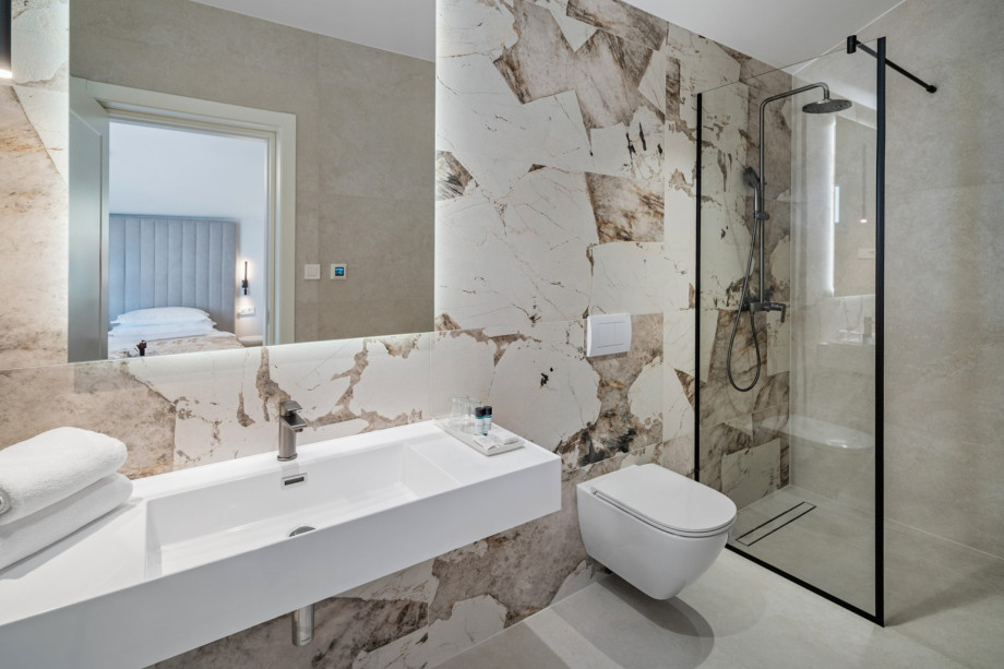 An en-suite bathroom with a shower, a sink, and a toilet