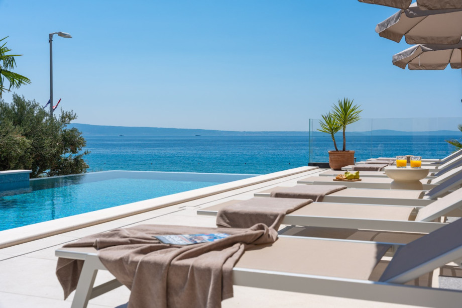 Expansive sun deck with 8 comfortable deck chairs, outdoor shower, and vibrant parasols for those sunny days.