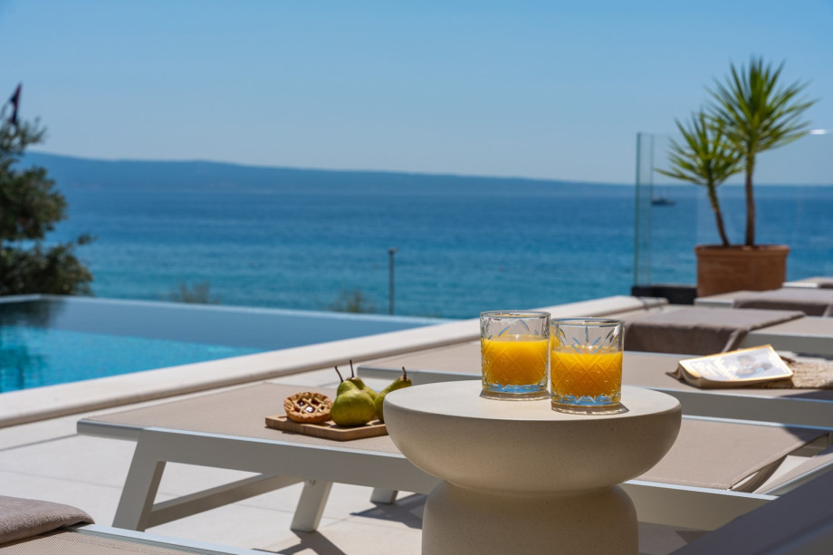 Expansive sun deck with 8 comfortable deck chairs, outdoor shower, and vibrant parasols for sunny days, where you can refresh yourself with delicious food and drinks.