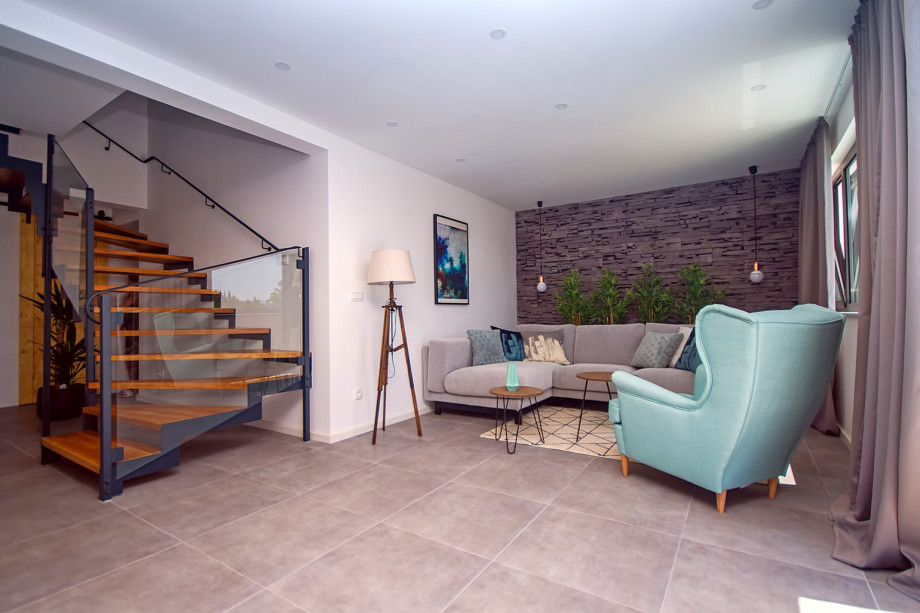 Living area with exit to the pool and stairs for upper floor