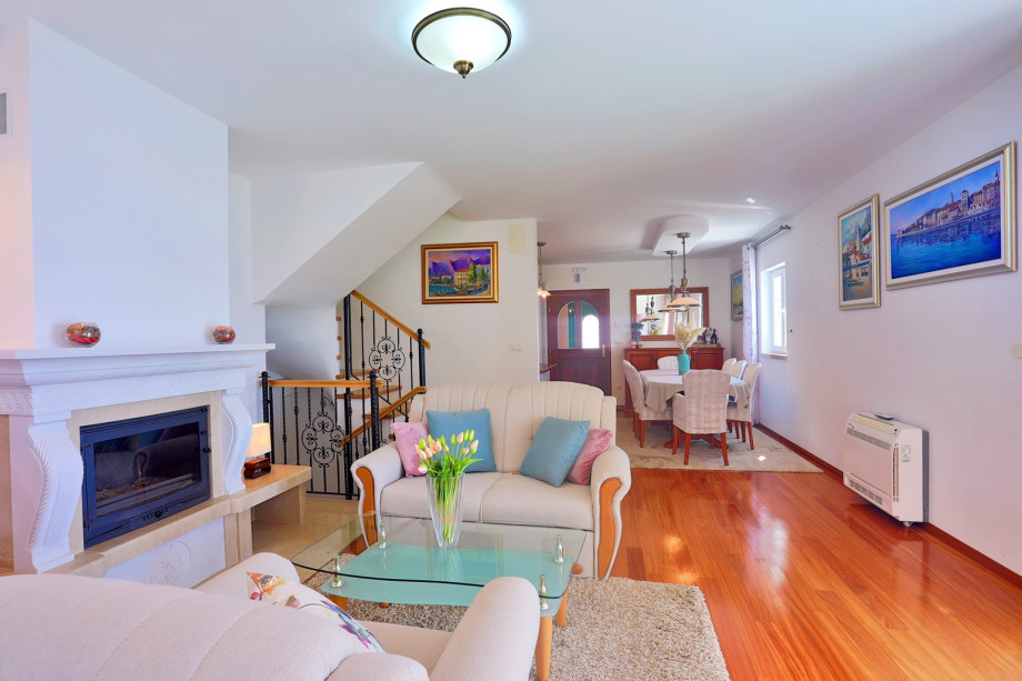 Living area (with exit to BBQ), TV, fireplace and dining area with kitchen