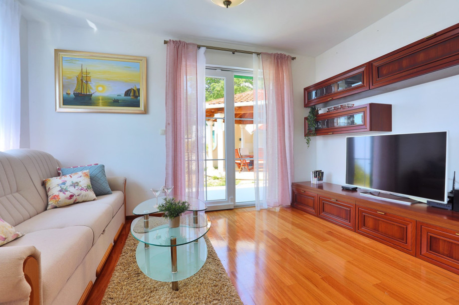 Spacious living area on the ground floor with TV, AC, and exit to the terrace.