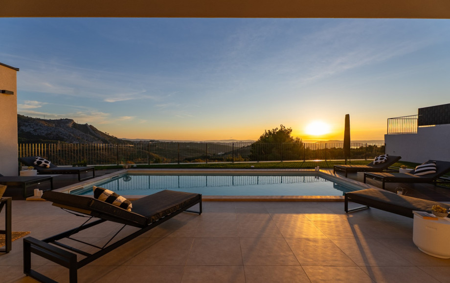 The private pool and sun terrace bathed in the warm light of the sunrise, creating a serene escape.