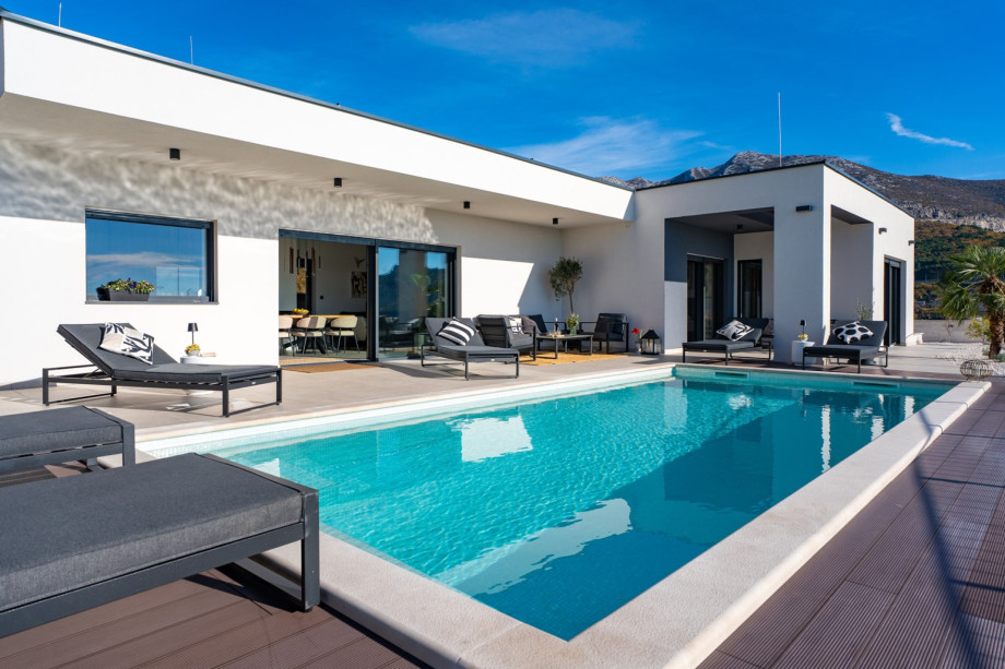 Modern villa design featuring a private pool and sun terrace with six loungers.