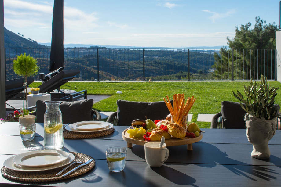 Al fresco dining setup near the pool, perfect for enjoying meals with breathtaking panoramic views.